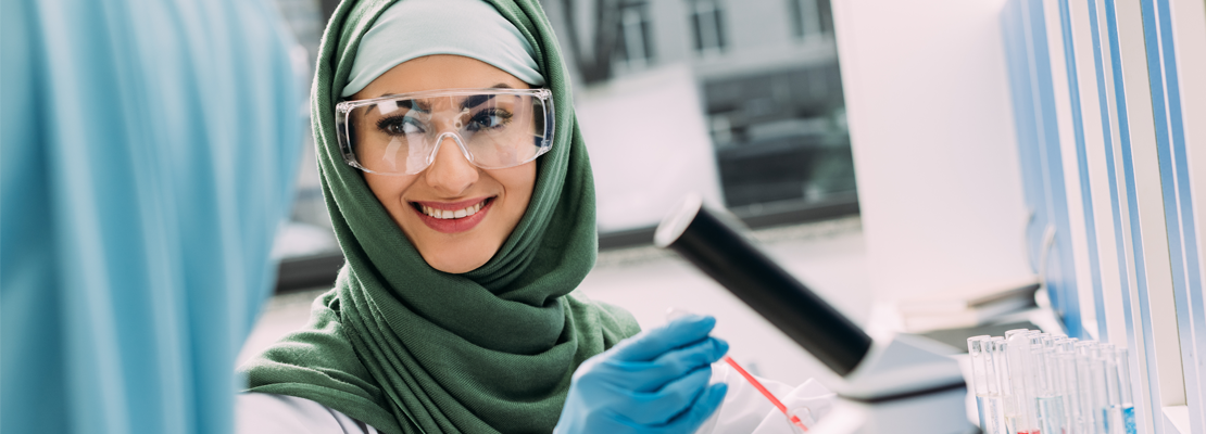 A female forensic expert wearing a hijab working in a lab in Newfoundland.